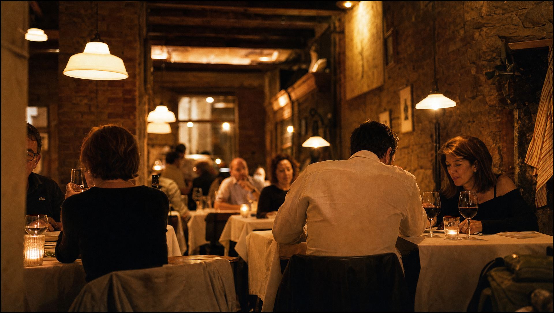 The Olivetta dining room at night, tables lit by candles and full of diners